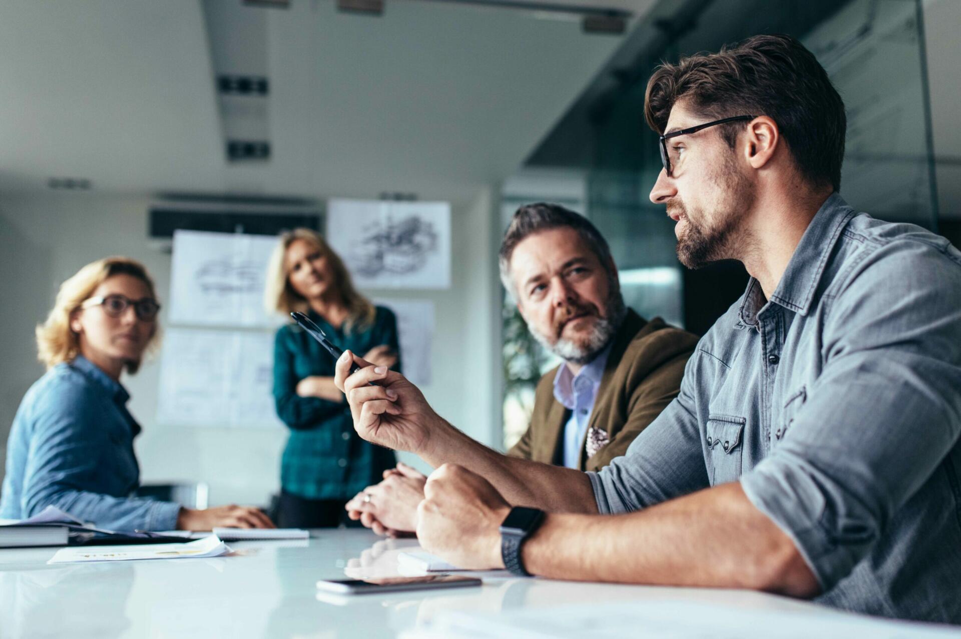 Colleagues discussing a project at a meeting table.